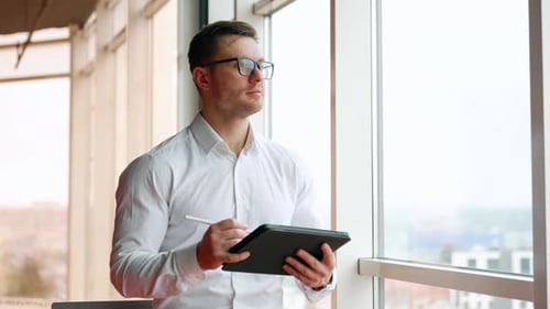 Man Using Tablet Computer in Bright Office