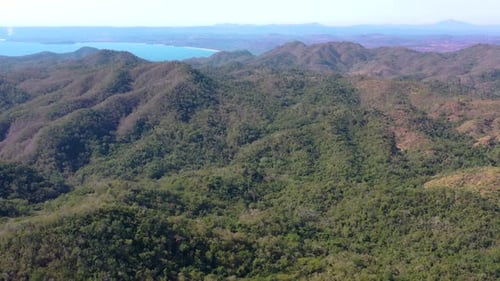 Atemberaubende Luftaufnahme der Berge und des blauen Ozeans in Mexiko. Drohne fliegt über den grünen Dschungelgipfel