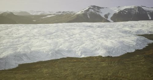 Majestic Glacier Stretches Across Rugged Landscape Near Mountain Range