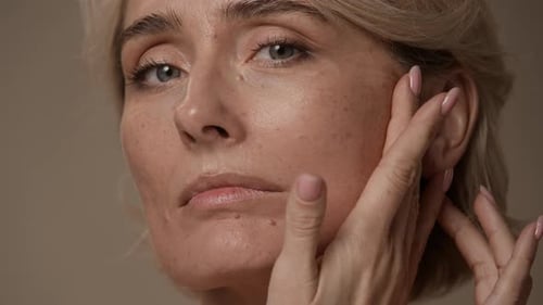 Woman Massaging Her Face in Close Up Studio Shot