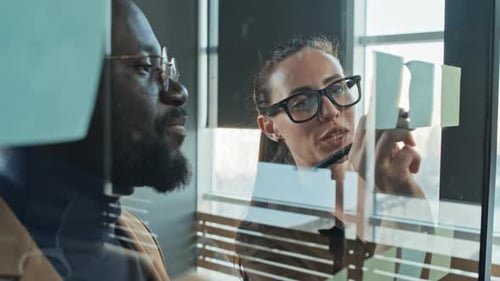 Two Professionals Collaborate on Sticky Note Plan