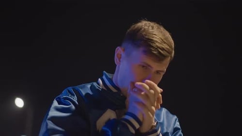 Contemplative Young Man Expressive Gestures at Night