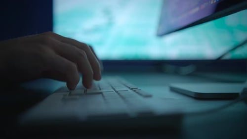 Hands Typing on Keyboard at Night