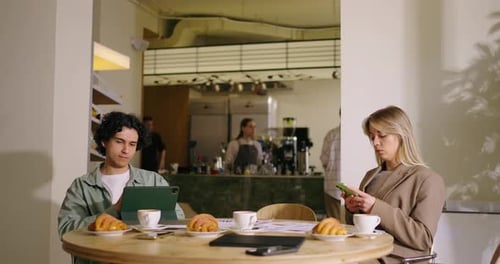 Internet Addicted People In Cafe Young Man And Woman Using Mobile Gadgets In Coffee Shop