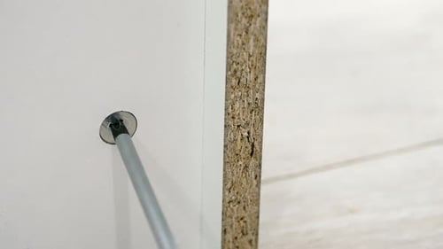 Screwdriver Tightens Screw in Furniture Close Up