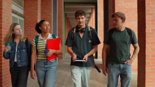 Group of Diverse College Students Walking Together Through Campus Hallway