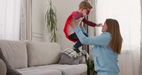 Boy Leaps from Sofa into Mother's Arms