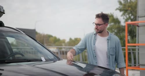 Young Man Comes to Car and Finds Parking Ticket Or Fine On Car Windshield