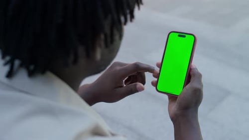 Man Using Smartphone with Green Screen Outdoors