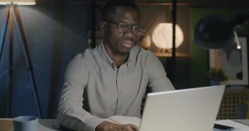 Young Man Working Late at Night on Laptop