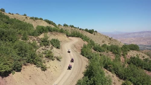 Aerial View Of Group Of People Riding On All Terrain Quadricycle Vehicle On Mountain Road