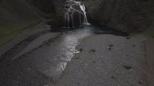 Aerial view of people jumping at Stjornarfoss waterfall, Iceland