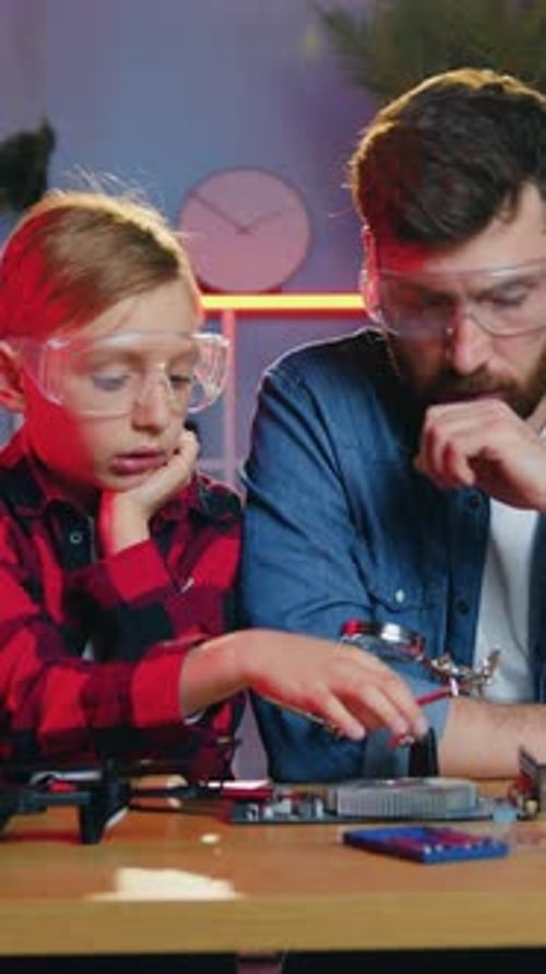 Boy and Man Working on Computer Hardware at Home