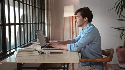 Business Man Working in Home Office and Typing on Keyboard of Laptop Computer