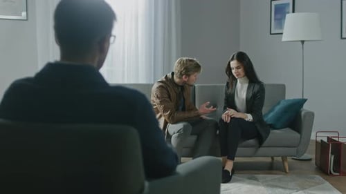 Young Couple on a Counseling Session with Psychotherapist. Back View of Therapist Taking Notes: Yo