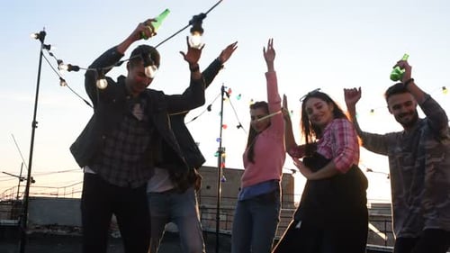 Young Adults Dancing and Celebrating at Rooftop Party