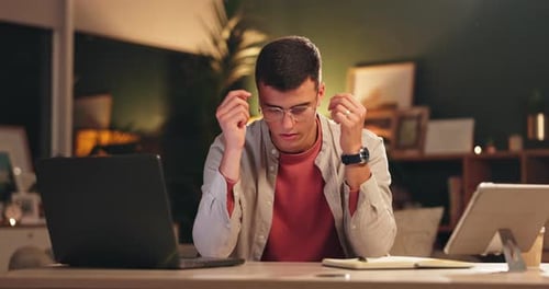 Student, man and tired in home at night with exam stress, university anxiety and overworked at desk