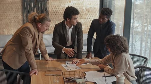 Diverse Startup Team Brainstorming over Performance Chart in Office