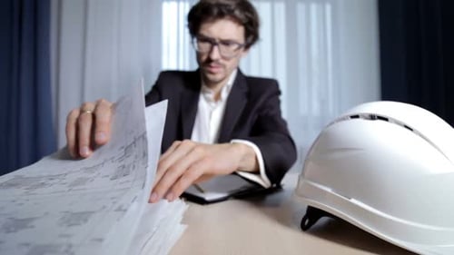 The design engineer works with drawings. Calculation and planning of buildings.
