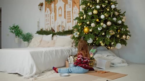 Child Opens Christmas Presents Under Decorated Tree