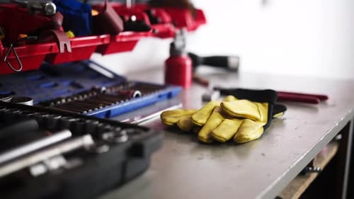 Banco de trabajo para mecánicos con herramientas y guantes