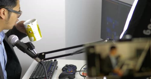 Man Talking into Microphone at White Desk