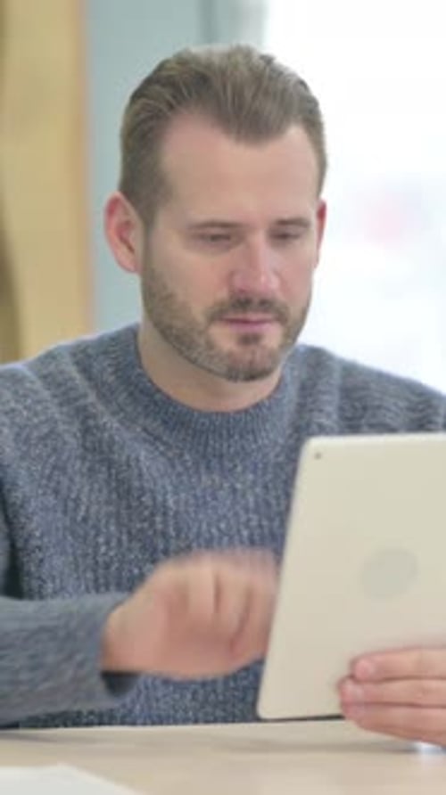 Man Using Tablet Receives Good News and Celebrates