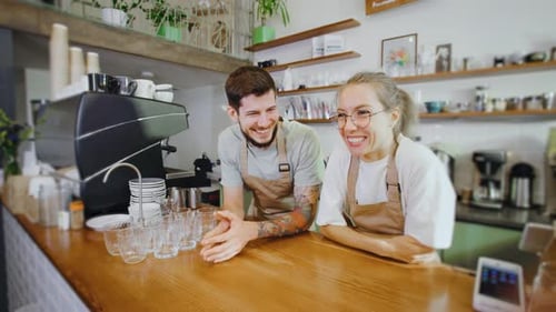 Smiling Baristas Chatting at Coffee Shop Counter
