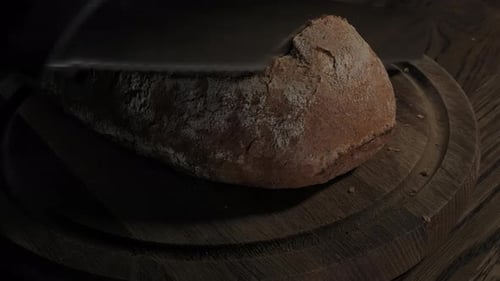 Cutting Slice of Homemade Crusty Rye Bread
