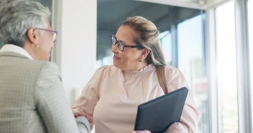 Women Shake Hands in Corporate Environment
