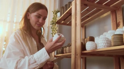 A young woman entrepreneur holding tablet checking craft products