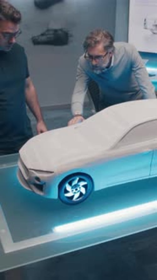 Two Automotive Developers Make Design Corrections in Sculpture of Prototype Car