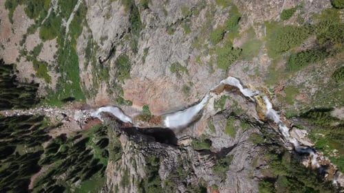 Cascading Waterfalls Flowing Through Rocky Mountain Valley