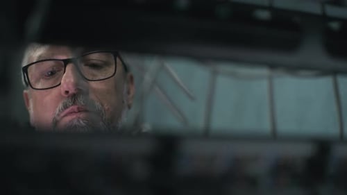 Close Up of Mature Network Administrator Inserting Cables Into Server Rack
