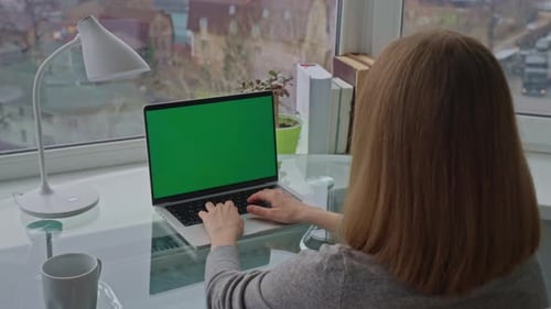 Woman Works at Laptop with Green Screen at Home