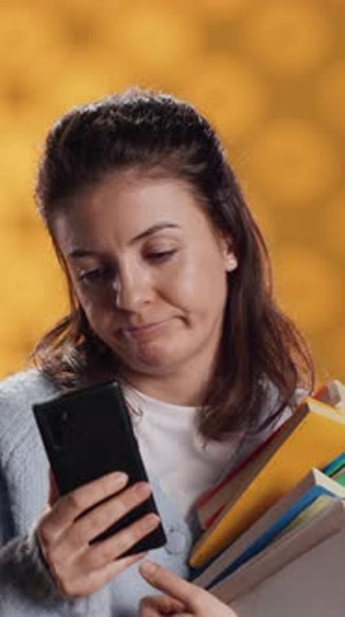 Vertical Video Upset Woman Holding Stack of Book Preparing for School Exam Using Phone