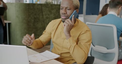 Professional Man Working at Desk Talking on Phone