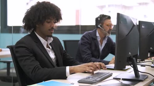 Tired Man Types on Computer in Office