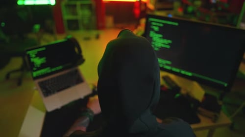 Hacker Writing Code Cracking Computer Man Programmer in Hoodie Cracks System Using Computer in Dark