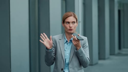 Businesswoman Talking on Smartphone in Modern Office Building Corridor During Work Hours