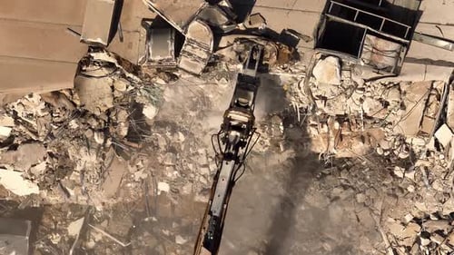Building demolition excavator using Pulverizer Jaws to demolish a residential building