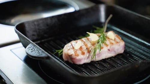A Steaming Beef Tenderloin Steak is Grilled in a Grill Pan
