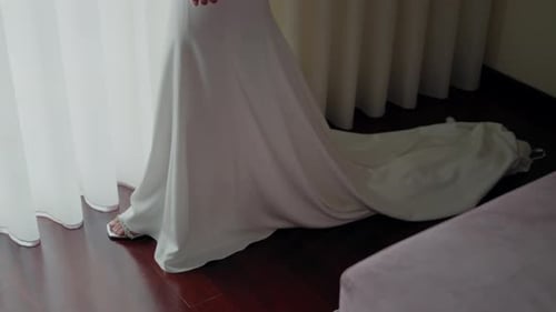 Elegant Bride in Wedding Dress Standing by Window