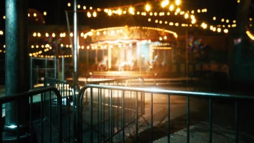 Empty Amusement Park at Night with Glowing Lights and Silent Rides