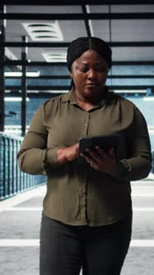 Vertikaler Video-Rechenzentrumsingenieur überwacht Rechenzentrumsmetriken auf dem Tablet