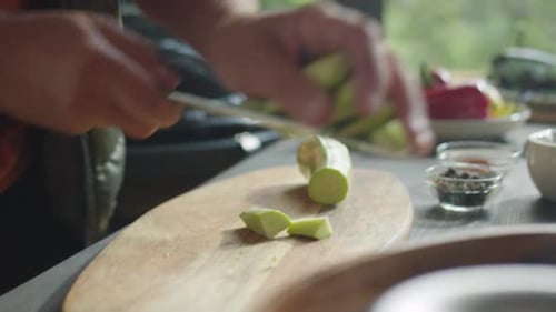 Männliche Hände schneiden frische Zucchini