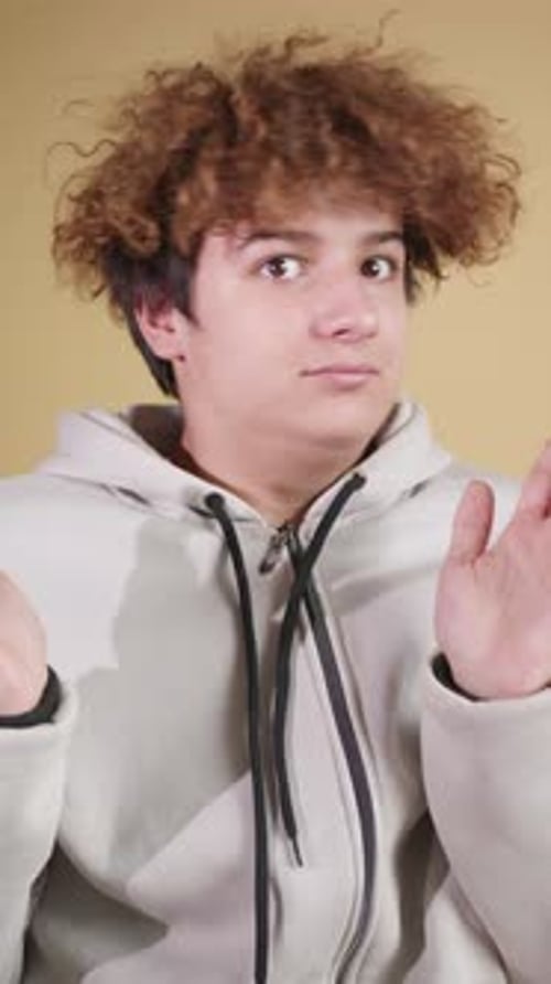 A Cute Teenager Sits His Gestures and Facial Expressions Expressing Surprise and Ignorance Slow