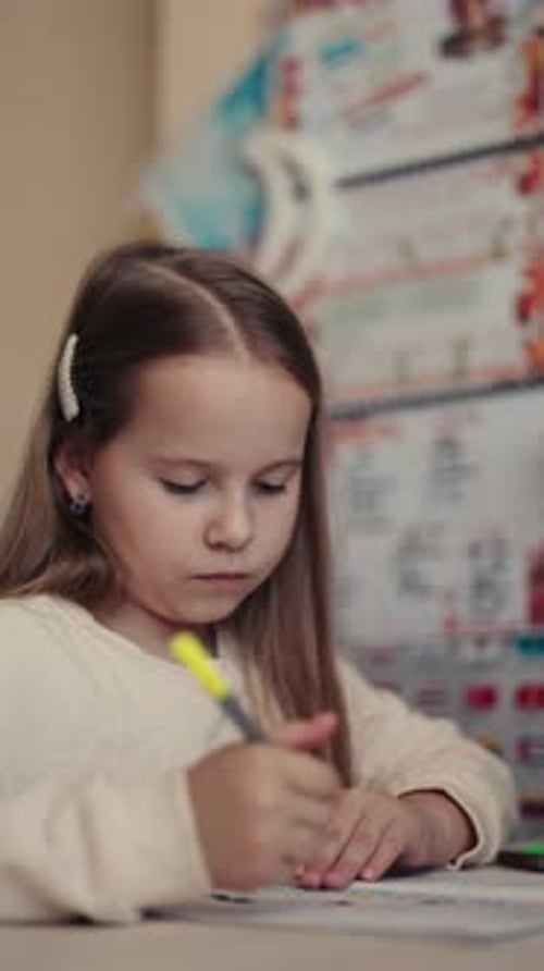 Young Girl Focused on Homework A Vertical Video of a Child Learning
