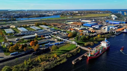 Tanker Ship At Riga Port Terminal On Daugava River On Sunny Day In Autumn. aerial orbiting shot