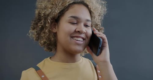 Woman with Curly Hair Chatting on Mobile Phone